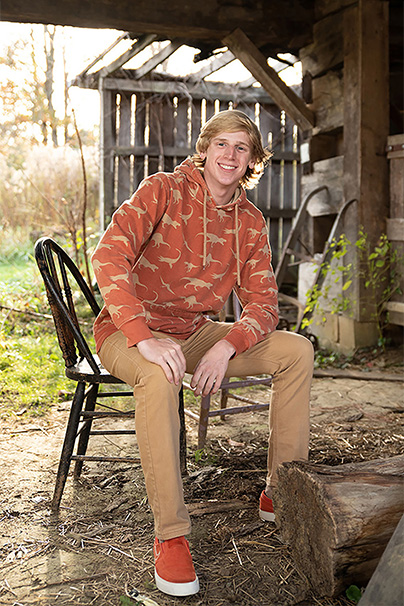 senior guy sitting on chair in barn
