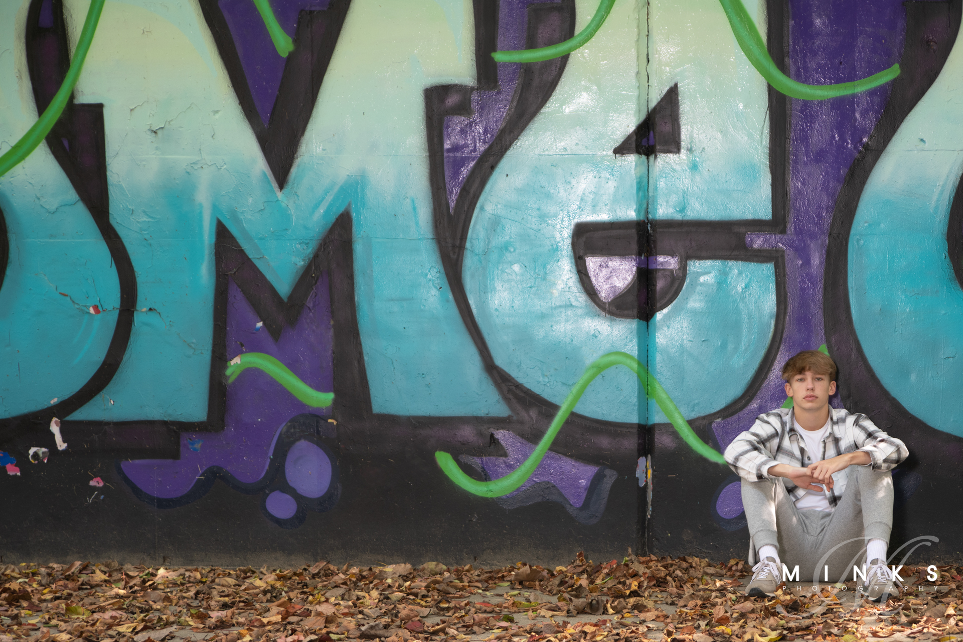 senior guy in front of graffiti wall in cincinnati ohio
