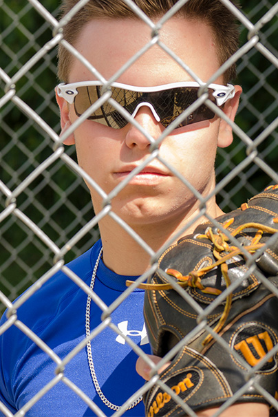 Senior guy in dugout with sunglasses and glove