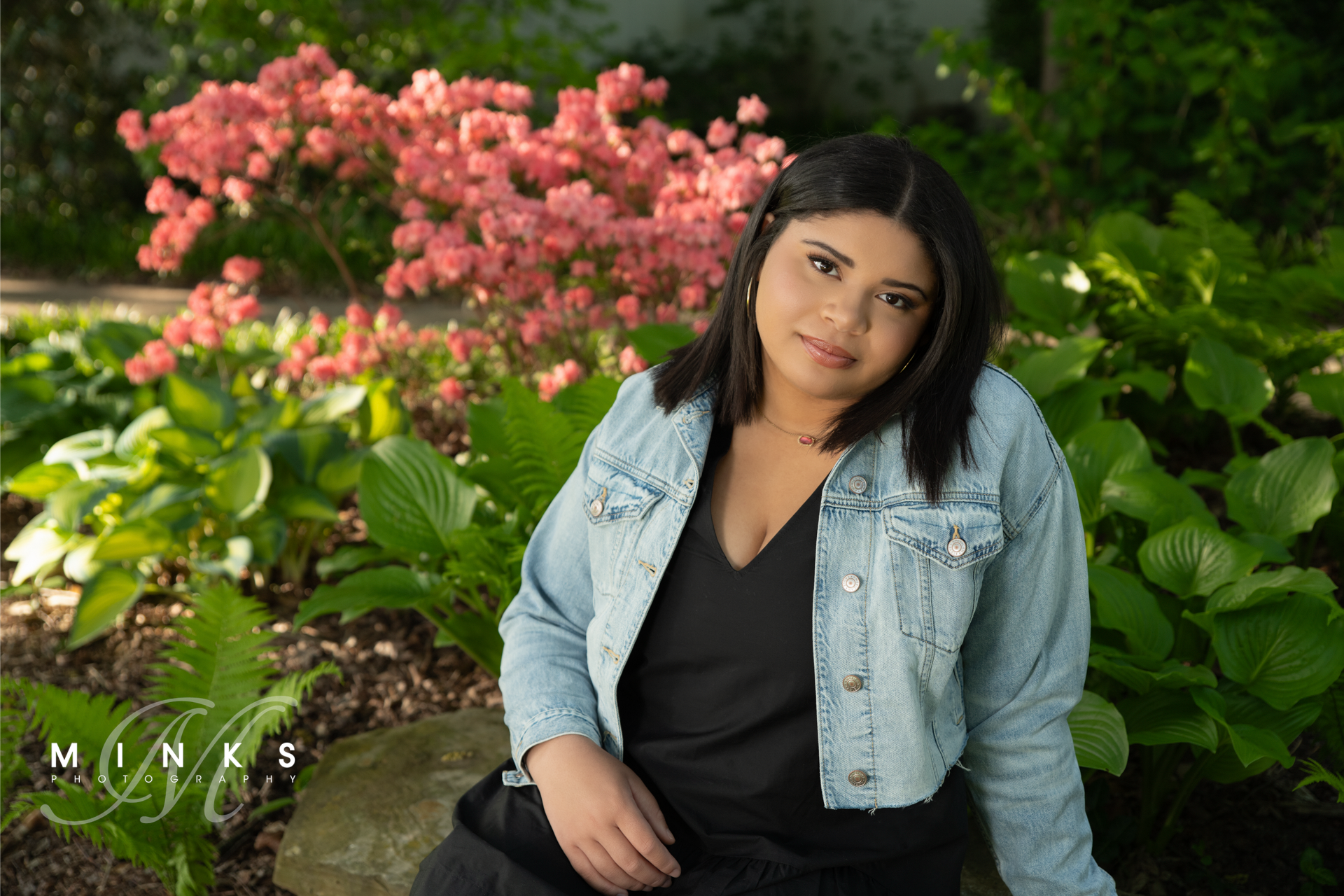 high school senior girl sitting in front of flowers