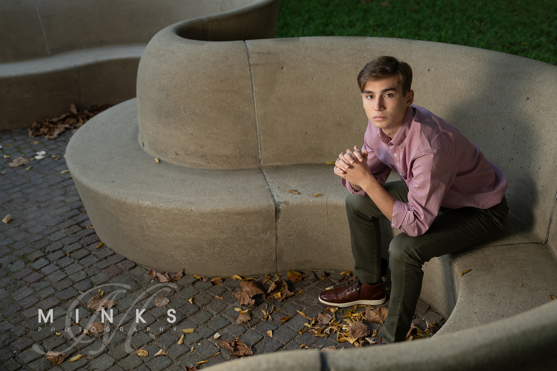 senior guy sitting on curved cement bench