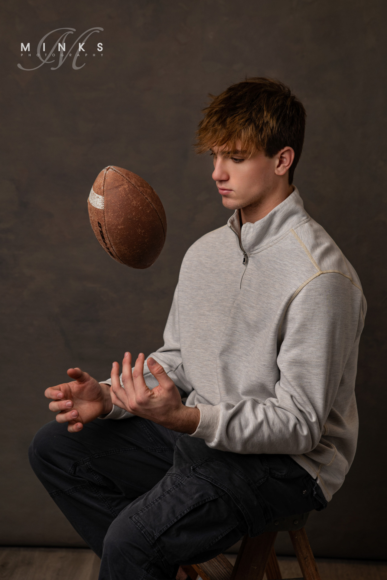 high school senior guy in studio with football